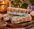 Three tied sage bundles arranged on a wooden tray.